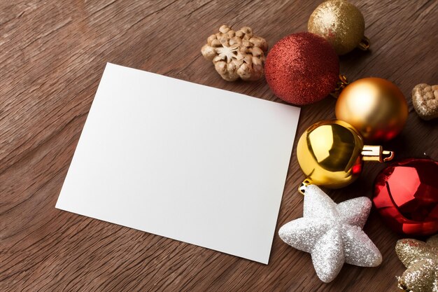 Hermosa maqueta de una tarjeta blanca con adornos navideños en el costado de la tarjeta