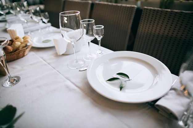 Hermosa mesa de boda platos blancos sobre mantel blanco