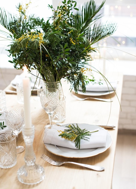 Hermosa mesa de primavera con hojas verdes y ramas de mimosa