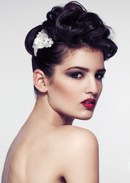 Hermosa modelo con accesorios de boda para el cabello y maquillaje aislado en blanco backgruond