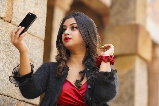 Hermosa modelo femenina india tomando selfie disparar al aire libre