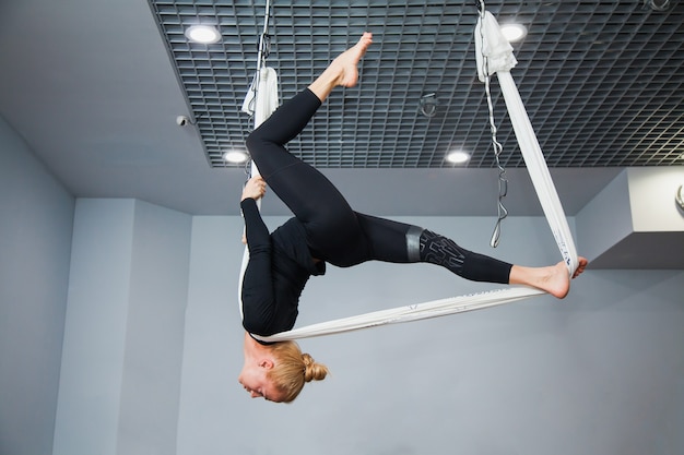 Hermosa modelo de fitness en hamaca de yoga voladora