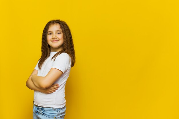 Hermosa modelo de moda en la pared del estudio amarillo