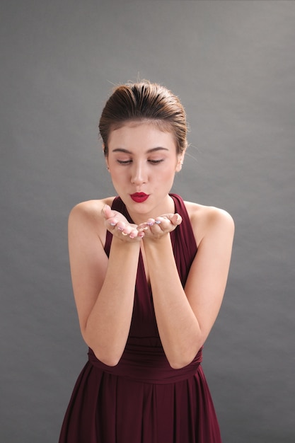 Foto hermosa modelo mostrando las manos y sorpresa para presentar el producto sobre fondo gris