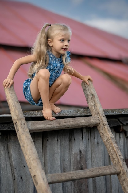 Hermosa modelo de niña sentada en las escaleras en el techo