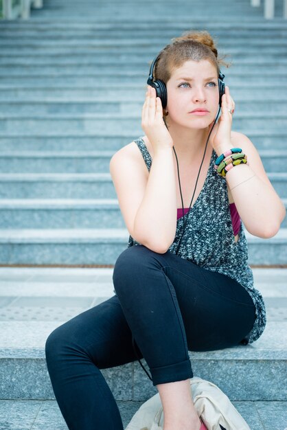 hermosa y moderna mujer joven y elegante escuchando música