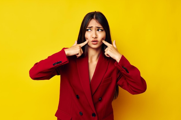 Hermosa morena en una chaqueta roja cosmética modelo de estudio de sonrisa inalterada