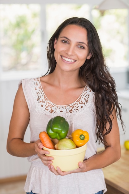 Hermosa morena con plato de verduras