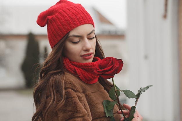 Hermosa morena con rosa roja en sus manos