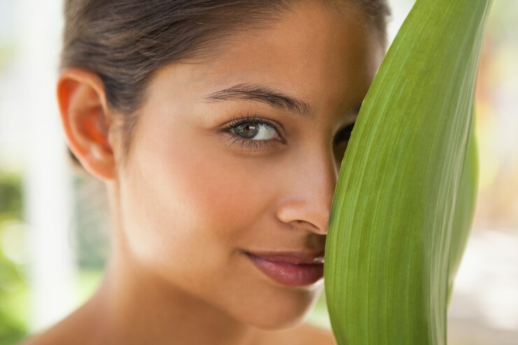 Foto hermosa morena sonriendo con hoja verde