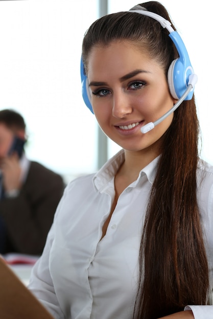 Hermosa morena sonriente empleado de call center en el trabajo