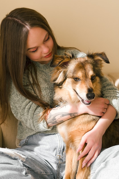 Hermosa mujer abrazando a su perro retrato de estilo de vida en casa