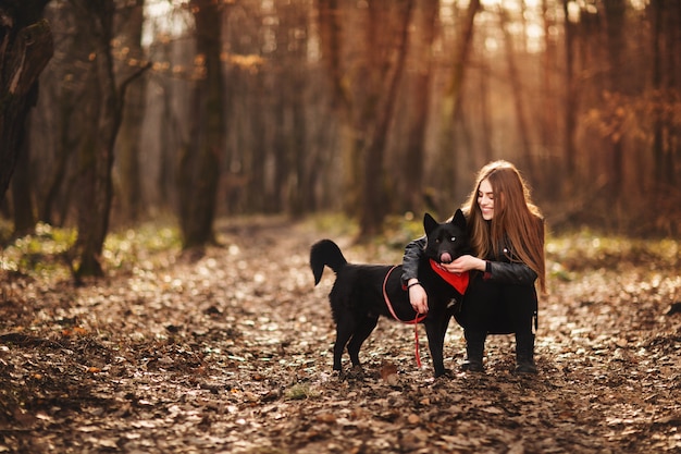 Hermosa mujer acariciando a su perro al aire libre