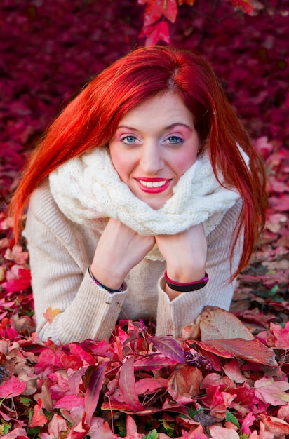 hermosa mujer acostada en hojas de otoño