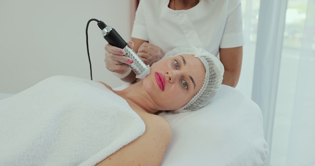 Hermosa mujer acostada en el spa y con procedimientos faciales. Concepto de cosmetología y spa.