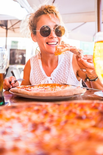 Hermosa mujer adulta de mediana edad hermosa disfrutando de una sabrosa pizza natural italiana en el restaurante pizzería - la gente come comida tradicional italiana - estilo de vida saludable vegetariano y vegano