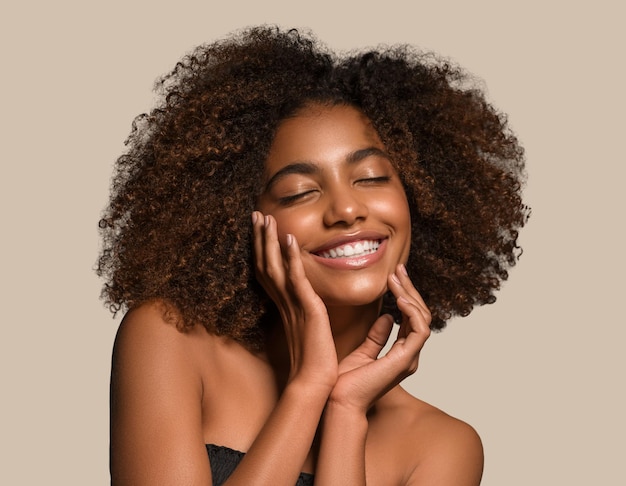 Hermosa mujer africana camiseta negra retrato corte de pelo afro tocando su cara Fondo de color marrón