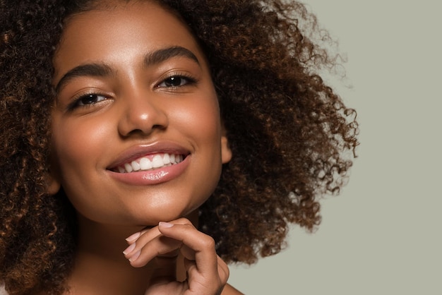 Hermosa mujer africana retrato de camiseta blanca corte de pelo afro tocando su rostro Color de fondo verde