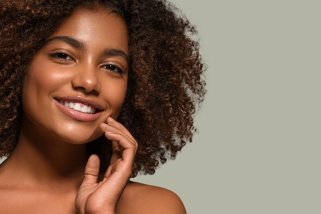 Hermosa mujer africana retrato de camiseta negra corte de pelo afro tocando su rostro Color de fondo verde