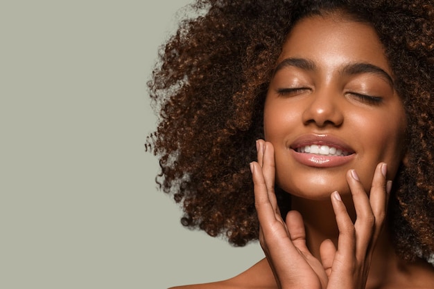 Hermosa mujer africana retrato de camiseta negra corte de pelo afro tocando su rostro Color de fondo verde