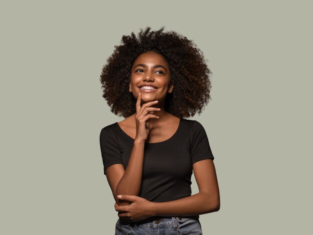 Hermosa mujer africana retrato de camiseta negra corte de pelo afro tocando su rostro Color de fondo verde