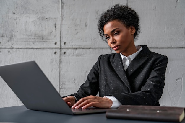 Hermosa mujer africana trabajando con laptop