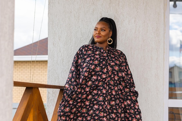 Hermosa mujer afroamericana disfrutando de la noche en el pueblo y la naturaleza en la terraza de la casa de campo Diversidad e inclusión y concepto de cabaña