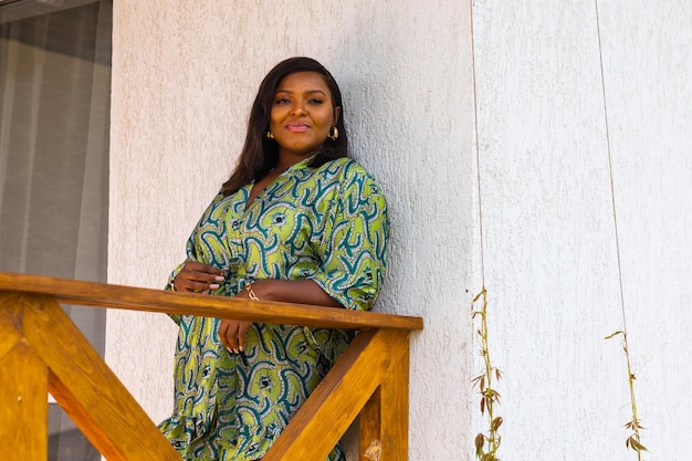 Hermosa mujer afroamericana disfrutando de la noche en el pueblo y la naturaleza en la terraza de la casa de campo Diversidad e inclusión y concepto de cabaña