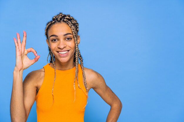 Hermosa mujer afroamericana con pigtailson pared de color