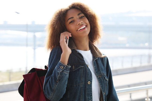 Hermosa mujer afroamericana usando el móvil en la calle Concepto de comunicación y estilo de vida