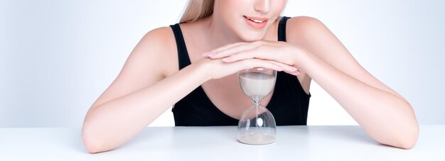 Hermosa mujer agradable con antienvejecimiento de reloj de arena como concepto de cuidado de la piel