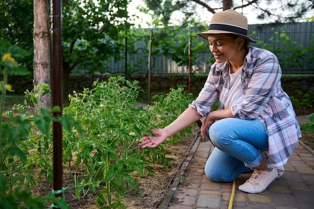 Hermosa mujer agricultora próspera disfrutando de la jardinería en primavera Horticultor agricultor jardinero propietario de granja ecológica