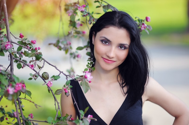 Hermosa mujer al aire libre en un floreciente jardín de primavera