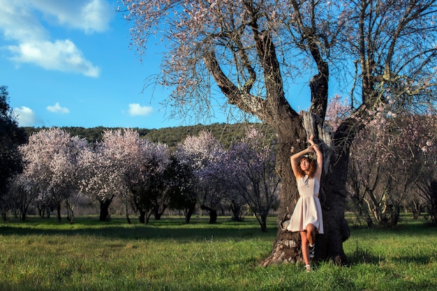 Hermosa mujer al lado de un almendro