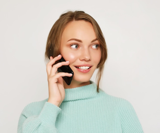 Hermosa mujer alegre hablando por teléfono móvil