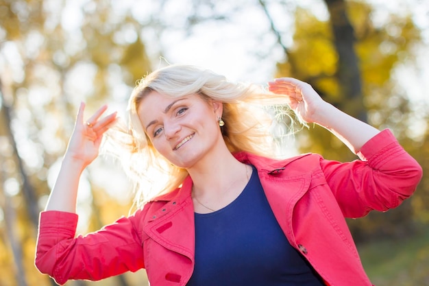 Hermosa mujer alegre sobre fondo de otoño