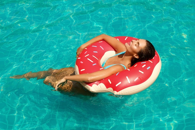 Hermosa mujer y anillo de natación inflable en forma de donut