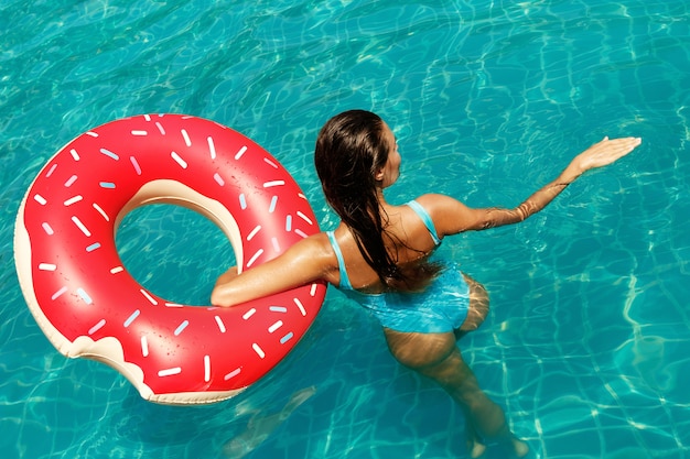Hermosa mujer y anillo de natación inflable en forma de donut