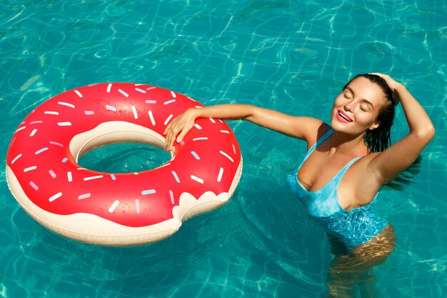 Hermosa mujer y anillo de natación inflable en forma de donut