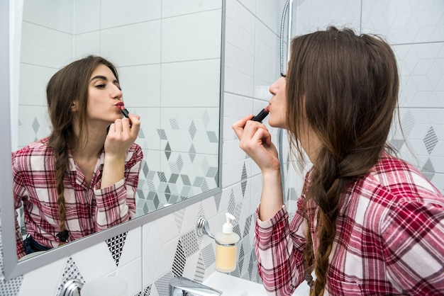 Hermosa mujer aplicando lápiz labial