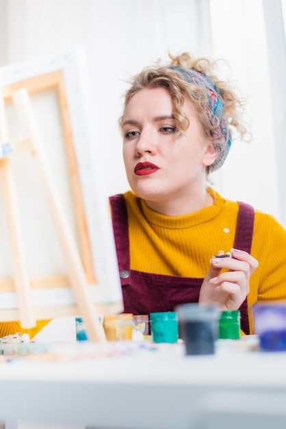 Foto hermosa mujer artista pinta sobre lienzo en casa