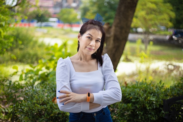 Hermosa mujer asiática de 40 años de edad con fondo de naturaleza al aire libre