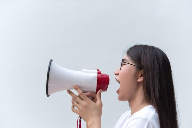 Hermosa mujer asiática con altavoz en mano sobre fondo blanco concepto de mujer enojada gente de Tailandia