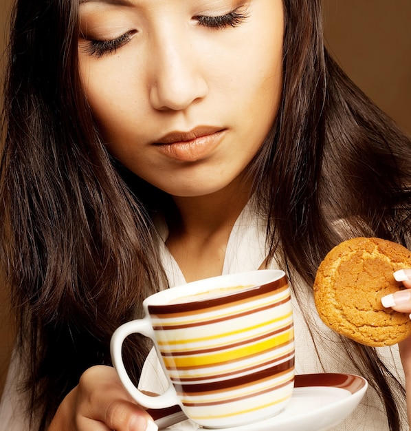 Hermosa mujer asiática bebiendo café o té