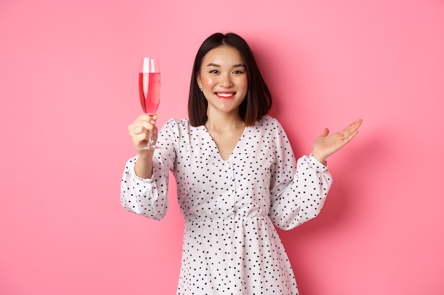 Hermosa mujer asiática bebiendo champán y sonriendo