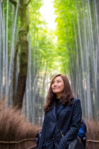 Foto una hermosa mujer asiática con bosque de bambú.