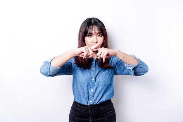 Hermosa mujer asiática con camisa azul con gesto de mano plantea rechazo o prohibición con espacio de copia