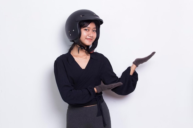 hermosa mujer asiática con casco de motocicleta apuntando con los dedos a diferentes direcciones