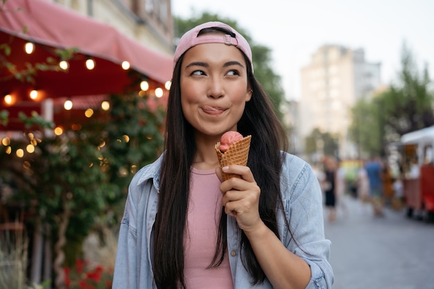 Hermosa mujer asiática comiendo helado en la calle