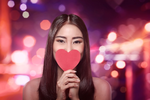 Hermosa mujer asiática con un corazón rojo